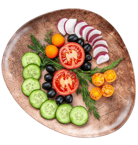 Ahşap bir tabakta sunulan salatalık, domates, turp ve zeytinden oluşan taze sebze salatasının üstten görünümü.